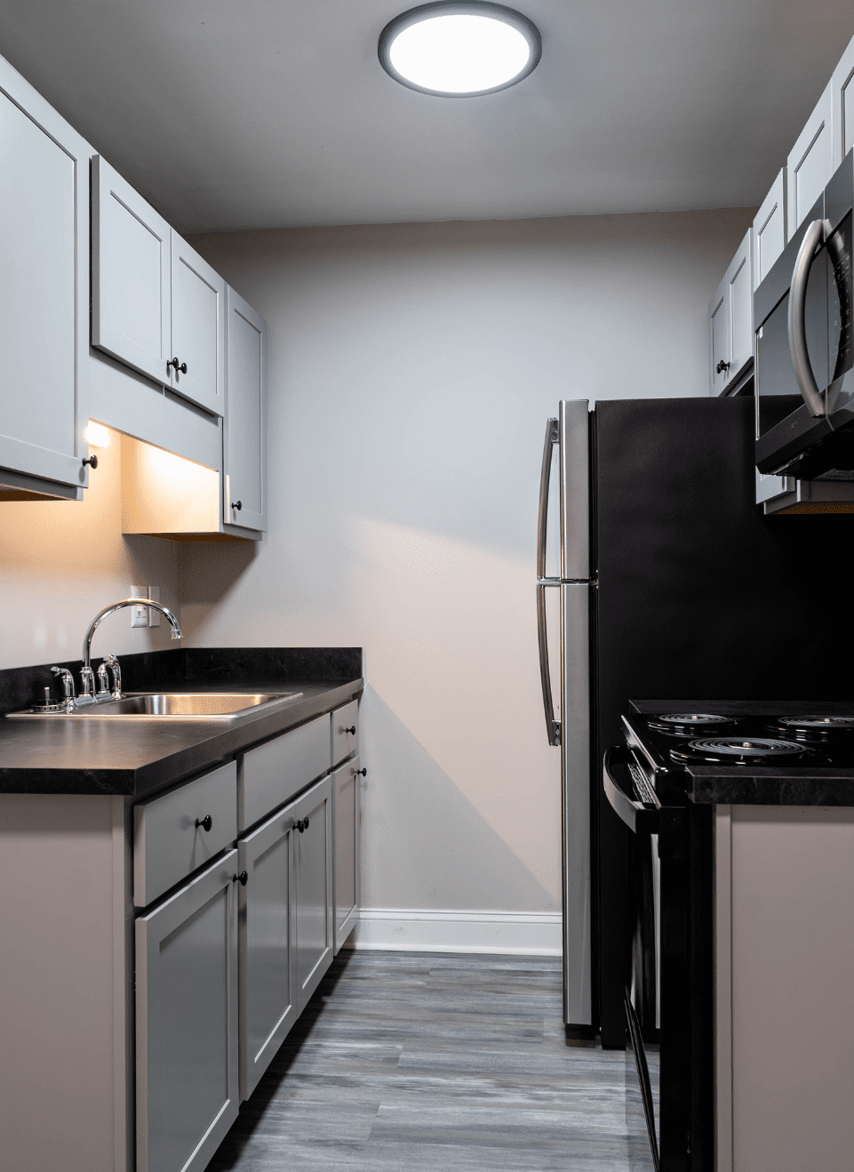 Oak Grove Kitchen Black Resize An apartment complex with a tree prominently positioned in front, enhancing the landscape and providing shade.